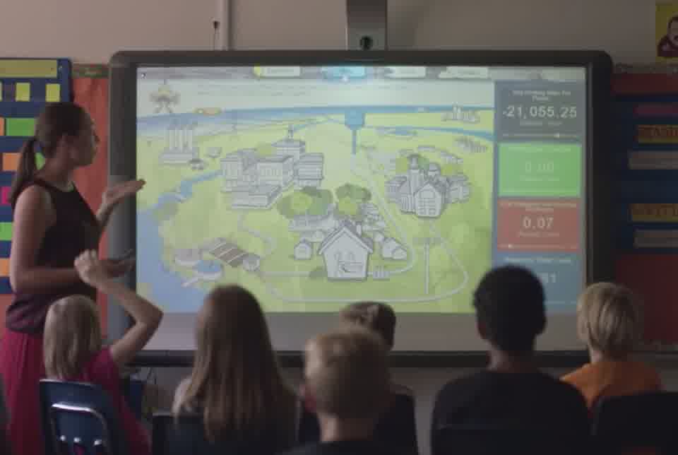 Elementary students in a classroom watch the Citywide Dashboard on a smartboard