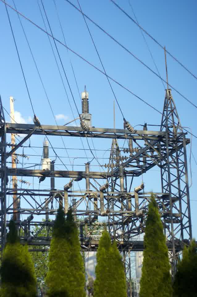 Electric substation towers against a blue sky