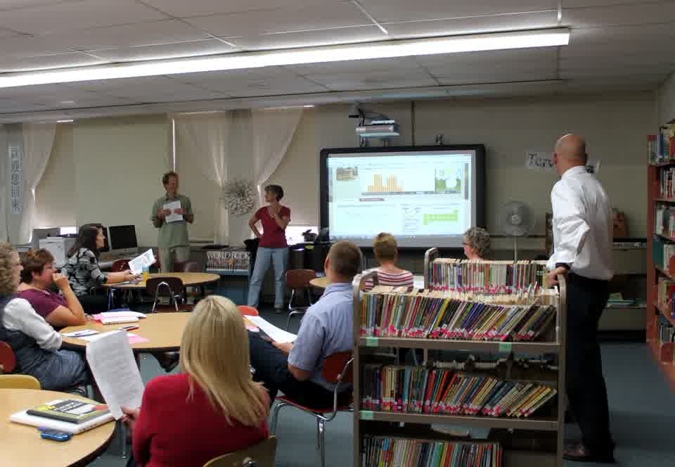 A group attending a workshop with a dashboard projected at the front of a library
