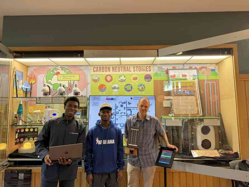 Visitors beside the Carbon Neutral Stories exhibit and touchpad at Oberlin College