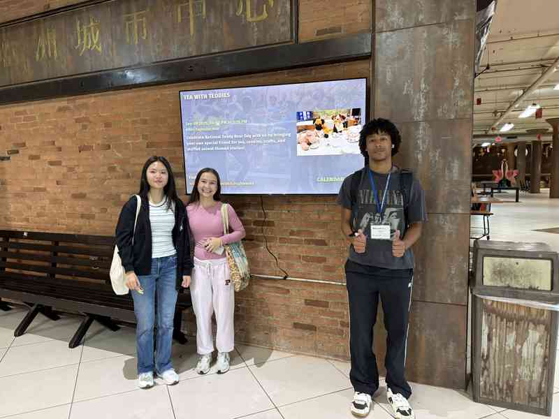 People beside a CommunityHub digital sign at Asian Town Center